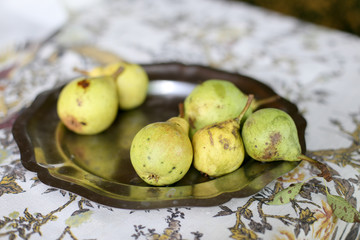 Pears on metal plate on the table