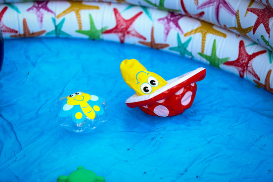 Inflatable colourful kid toys floating in an inflatable swimming pool