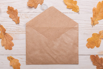 Autumn leaves, notebook and pencils on a white wooden background