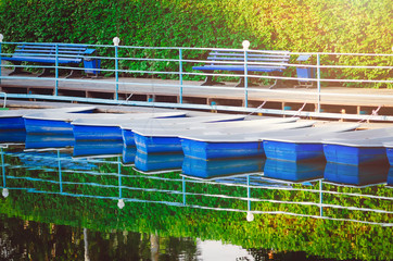 Blue boats on the pier in a recreation park.