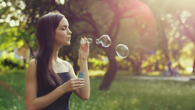 Teenage woman blowing bubbles
