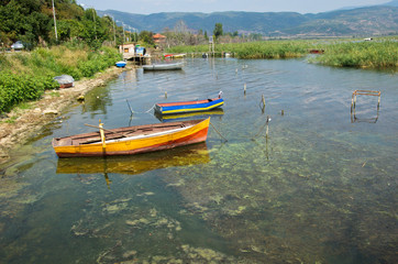 Fototapeta na wymiar old colorful wooden fish boats on lake shore with reed, Lake Dojran, Macedonia
