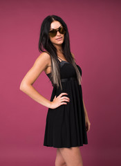 Happy young brunette woman in a black dress