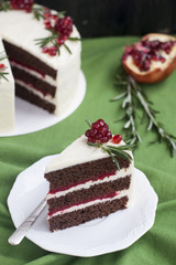 Chocolate cake with berry cream, white cheese cream, pomegranate berries and rosemary branches. Idea for a birthday cake or for a wedding cake..