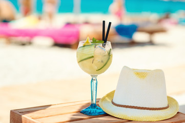 Cucumber drink cocktail, straw hat on wooden table