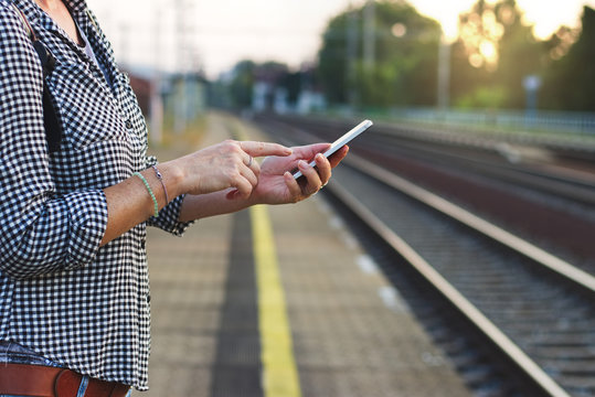 Woman using smart phone on train station