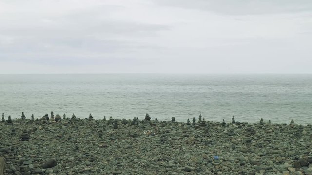 Little pyramides on ocean shore made of stones by tourists on Madeira Island