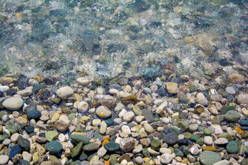 sea salt wave, water covers the coastal pebbles, stones