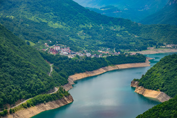 Naklejka na ściany i meble A picturesque turquoise lake can be seen from the top of a high mountain.