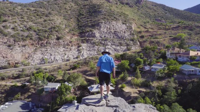 A man with Hat Looks Over Cliff in Bisbee Arizona