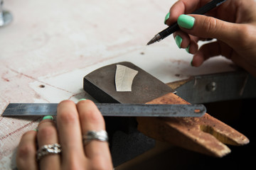 The process of making silver jewellery. Female artist hands close up. Crafting a silver ring, see the entire series.