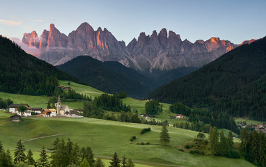 Village of Santa Magdalena and church on the Italian mountains Dolomites Alps at sunrise