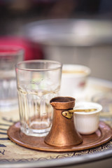 Obraz na płótnie Canvas Sarajevo, capital of Bosnia. Traditional handcrafted copper plated coffee filled with traditional foam Bosnian coffee served in an ornament Sarajevo set