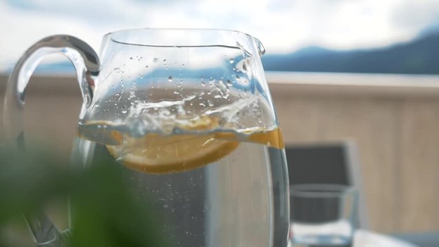 Dropping sliced citrons in a water carafe.