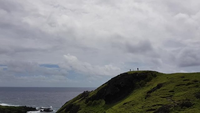 Tourists sightseeing on a hill in Batanes, Philippines.
