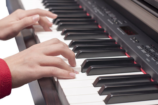Piyano çalan çocuk, tuşlar ve eller.