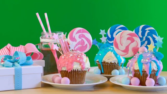 Pink and blue theme colorful novelty cupcakes decorated with candy and large lollipop for children's, teen's birthday, Valentine's or party celebrations, on removable chroma key background..