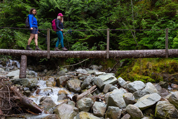 Hiking on a wooden bridge across a river creek in the woods. Taken on the trail to the top of Brunswick Mountain, North of Vancouver, BC, Canada.