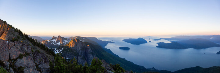 Fototapeta na wymiar Panoramic landscape view of Howe Sound during a vibrant summer sunrise. Taken from the top of Brunswick Mountain, North of Vancouver, BC, Canada.