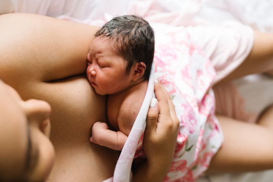 Woman feeding newborn daughter in hospital