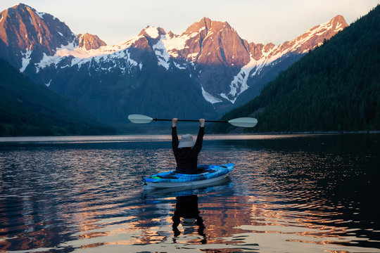 Adventurous man kayaking in the water surrounded by the Beautiful Canadian Mountain Landscape. Taken in Jones Lake, near Hope, East of Vancouver, BC, Canada.