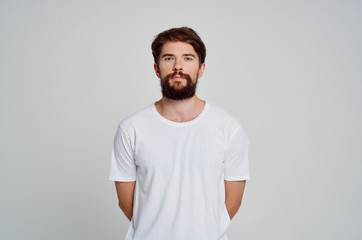 man with a beard in a white T-shirt logo