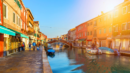 Fototapeta na wymiar Murano glass making island, water canal, bridge, boat and traditional buildings. Venice or Venezia, Italy, Europe.