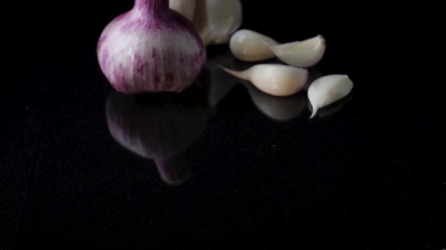 Onions and garlic over black background. Still-life of onions and falling garlic on black background
