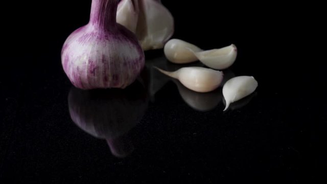 Onions and garlic over black background. Still-life of onions and falling garlic on black background