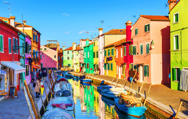 Naklejka na ściany i meble Beautiful view of the canals of Burano with boats and beautiful, colorful buildings. Burano village is famous for its colorful houses. Venice, Italy.