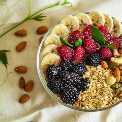 Eating healthy breakfast bowl. Fruit in a plate with a healthy meal. Raspberry, Banana, Nuts. dieting, Vegetarian food concept 
