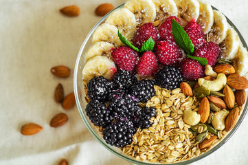 Eating healthy breakfast bowl. Fruit in a plate with a healthy meal. Raspberry, Banana, Nuts. dieting, Vegetarian food concept 