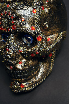 Skull decorated with colorful stones on black background
