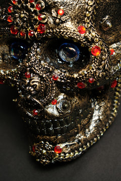 Skull decorated with colorful stones on black background