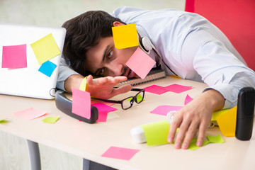 Young help desk operator working in office with many conflicting
