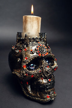 Skull decorated with colorful stones on black background