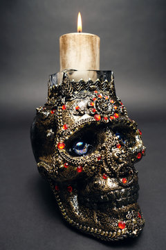 Skull decorated with colorful stones on black background