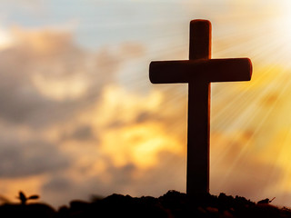 Silhouettes of crucifix symbol with bright sunbeam on the sky