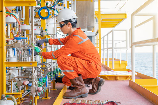 Instrument maintenance technician fixing chemical diaphragm pump at offshore oil and gas wellhead remote platform, A worker working on hazardous work place.