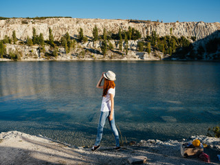 Fototapeta na wymiar woman in a hat by the lake summer