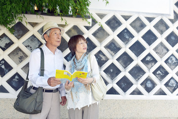 旅先の街角で、ガイドブックを手にするシニア旅先の街角で、ガイドブックを手にするシニア夫婦
