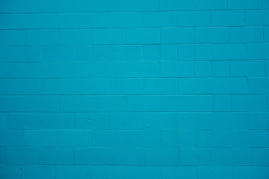 Concrete cinder block wall painted turquoise blue.