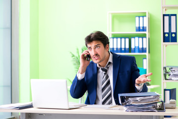 Businessman unhappy with excessive work sitting in the office 