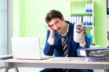 Businessman unhappy with excessive work sitting in the office 