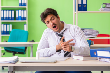 Sick and unhappy businessman sitting in the office 