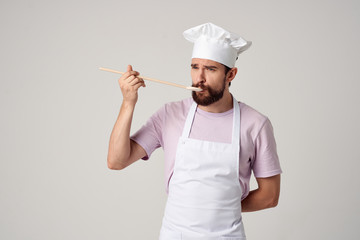 man tastes from a spoon cooking cook