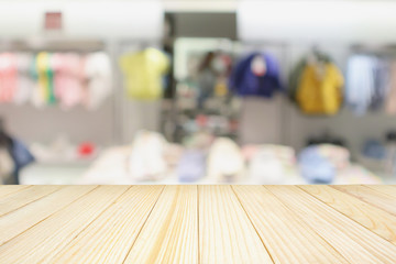 Empty wood table with blur kid fashionable boutique clothing store window display in shopping mall