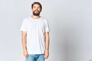 a man with a beard in a white T-shirt on a light background