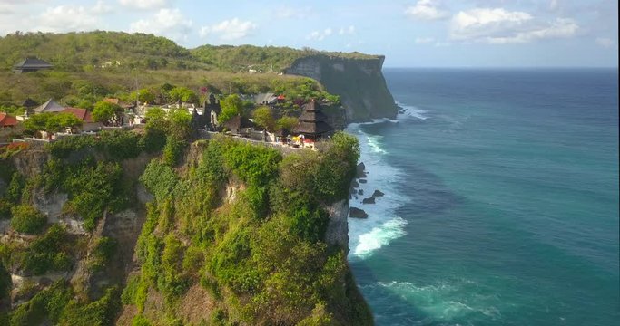 Pura Uluwatu temple. Stone cliffs, ocean waves and ocean landscape. Aerial view. Bali island, Indonesia.