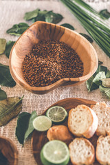 Teak Wooden bowl with buckwheat porridge on table. Traditional russian food. Lime and bread on the table.